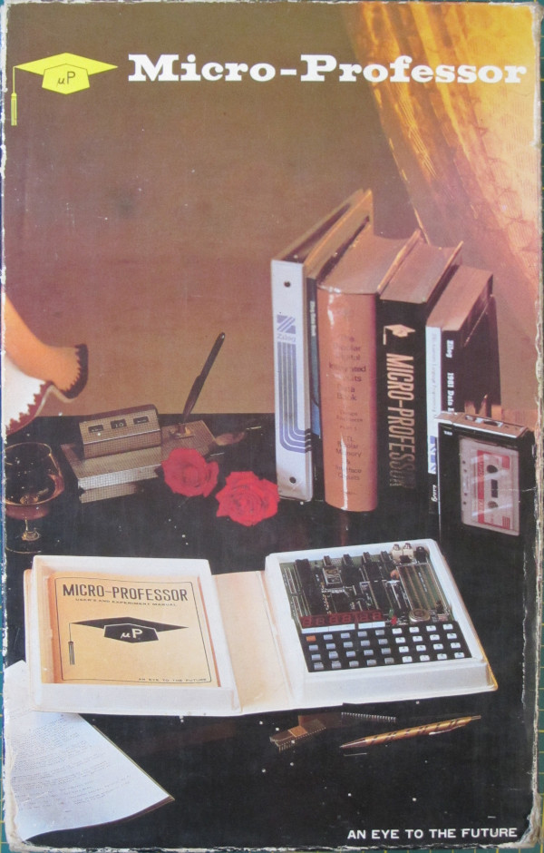 MPF-1
 box, showing the MPF-1 in a posh, pseudo study setting showing old-style shaded 
 lamp, glass of cognac, roses, technical books, I.C.s, pens