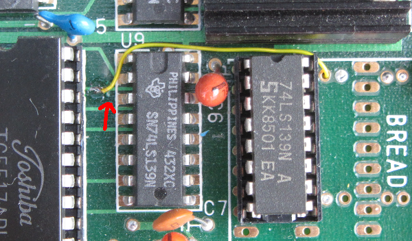 Photo of the PCB component side modification using half of a 74LS139. The red arrow points to the trace to be cut.